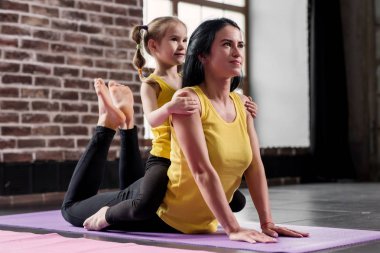 Mutlu genç gülümseyen kızı onu Spor Kulübü sarılma ise mat egzersiz germe yapıyor anne