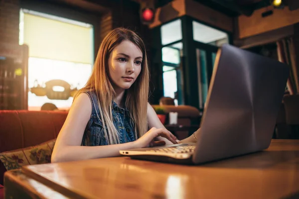 Top view of young female student working on laptop sitting at table — Stock Photo, Image