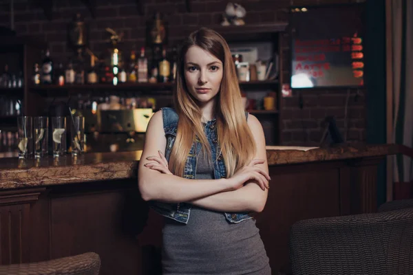 Portret van jonge vrouwelijke model met eerlijke haar leunend haar ellebogen op toog kijken camera in vintage restaurant — Stockfoto