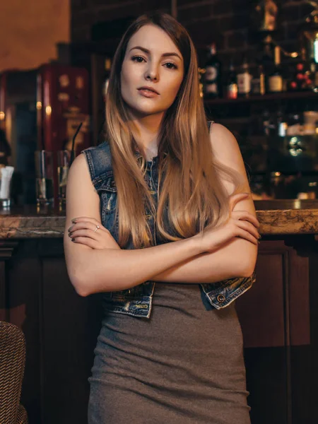 Portret młodego kobieta model z jasne włosy, nachylając jej łokcie na licznik, patrząc na kamery w vintage restaurant bar — Zdjęcie stockowe