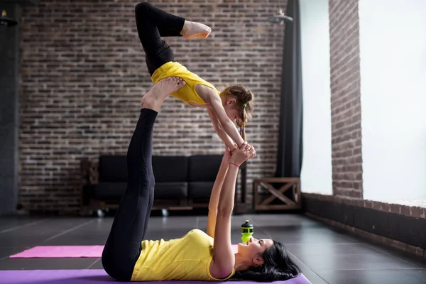 Mor och daughterdoing gymnastiska övningar tillsammans hemma — Stockfoto
