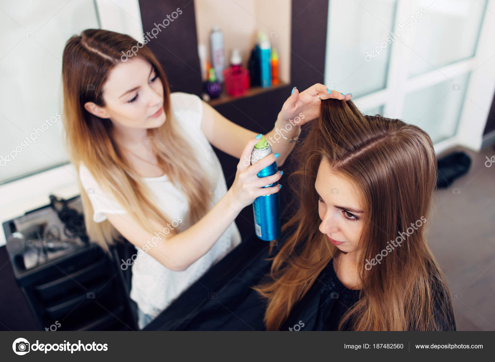 Professional hairdresser using hair spray working on young girl s hair in  beauty salon Stock Photo by ©undrey 187482560