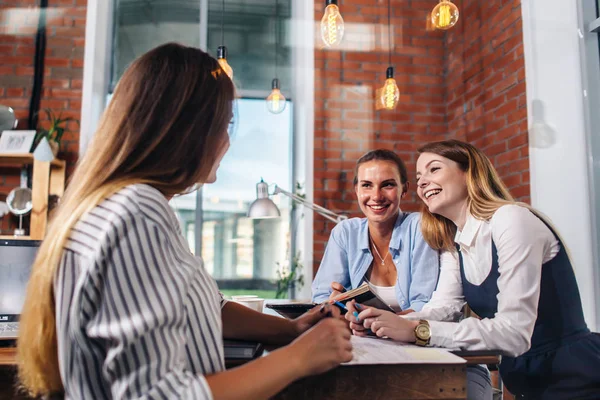 Young people discussing something with smile sitting at the office table. — Stock Photo, Image