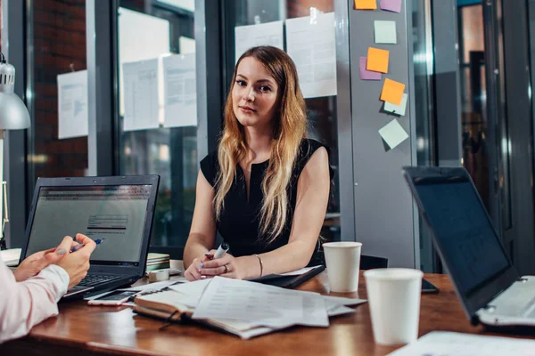 Donna sorridente che lavora seduta in un ufficio moderno — Foto Stock