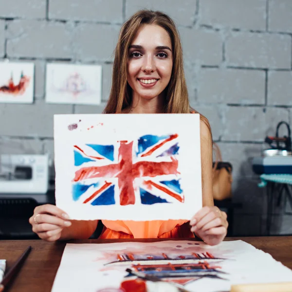 Smiling female artist showing her works, British flag drawn with watercolor technique — Stock Photo, Image