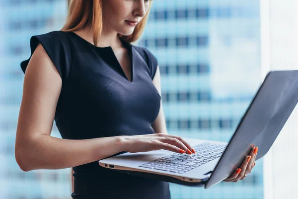 Närbild av kvinnliga arbetare håller laptop skriva e i kontorsbyggnad — Stockfoto