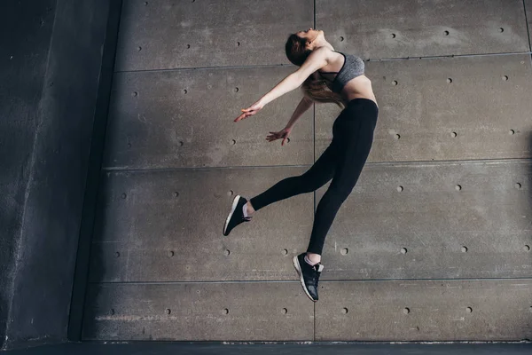 Sport ung kvinna gör baksidan bend hoppa — Stockfoto