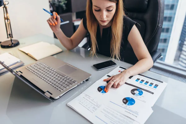 Geschäftsfrau liest Finanzbericht zur Analyse von Statistiken und zeigt auf Kuchendiagramm am Schreibtisch — Stockfoto