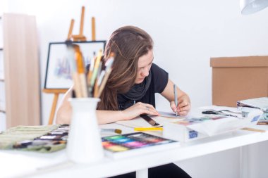 Genç kadın sanatçı ile Studio onun işyerinde kalem eskiz defteri kullanarak kroki çizim. Yan görünüm portre ilham ressam.