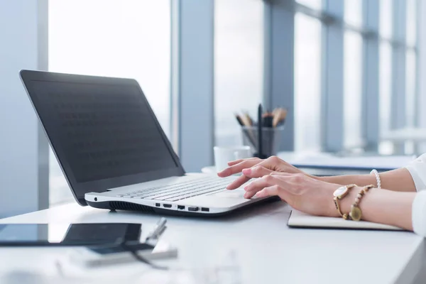 Женщина-работница использует ноутбук в офисе, работает с новым проектом. Женщина ведет блог дома в качестве фрилансера . — стоковое фото