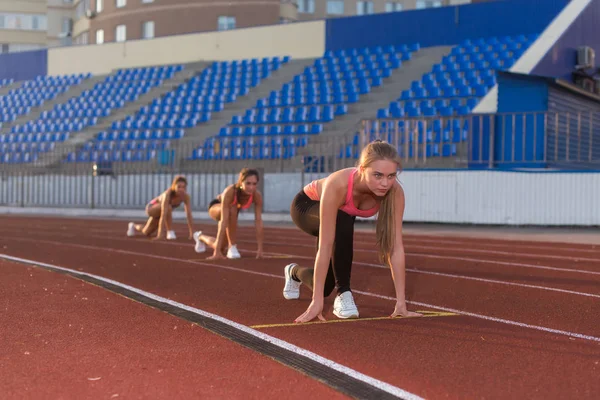 Fiatal nő sportoló a kiindulási helyzet indulásra készen a verseny. — Stock Fotó