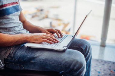 Havaalanı terminal dizüstü bilgisayar kullanan genç adam