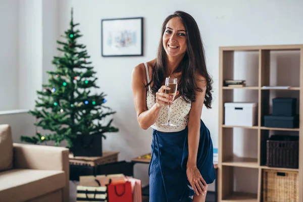 Χριστούγεννα, Πρωτοχρονιά. Χαμογελαστή γυναίκα στο σπίτι με ποτήρι αφρώδους οίνου. Διακοπές, γιορτή — Φωτογραφία Αρχείου