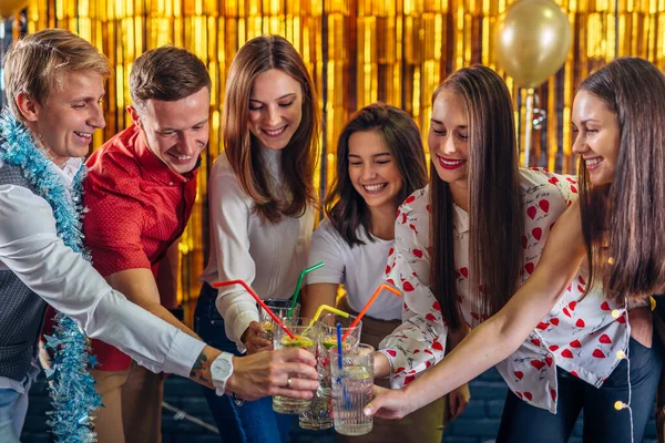 Grupo de pessoas que celebram o Natal ou a véspera de Ano Novo. Amigos brindar bebidas — Fotografia de Stock