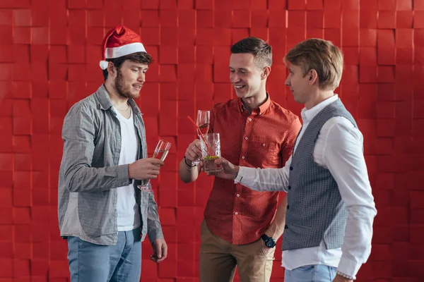 Három fiatalember ünnepli a karácsonyt vagy az újévet. — Stock Fotó