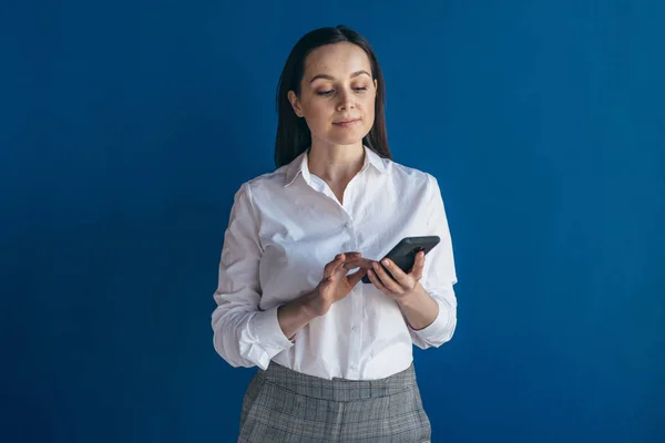 Junger Geschäftsmann schaut aufs Smartphone und nutzt mobile Anwendung. — Stockfoto