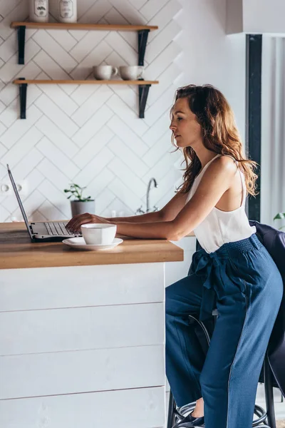 Frau benutzt Laptop während sie zu Hause sitzt. — Stockfoto