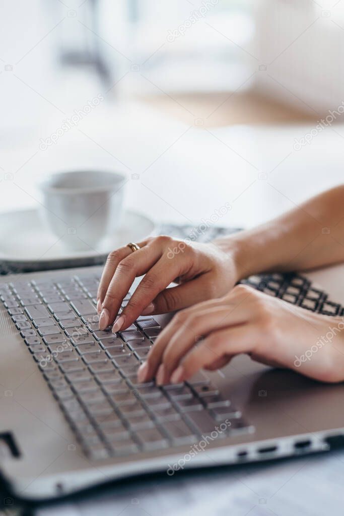 Woman using laptop typing on the keyboard Female hands close up
