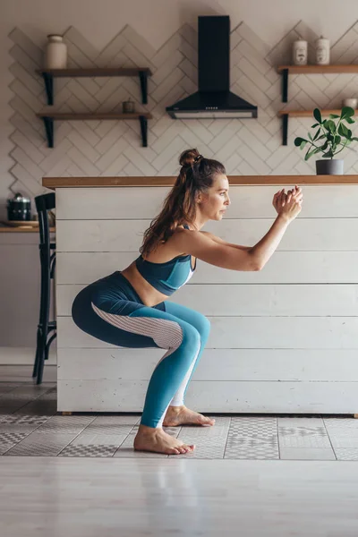 Een jonge vrouw die kraakpanden oefent. Vrouw die thuis traint — Stockfoto