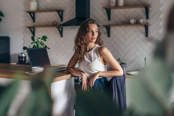 Молодая предпринимательница сидит за кухонным столом — стоковое фото
