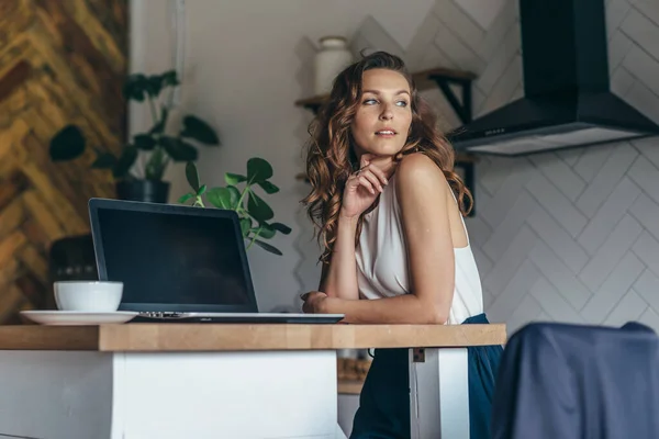 Fiatal nő dolgozik laptop és kávézás közben otthon — Stock Fotó