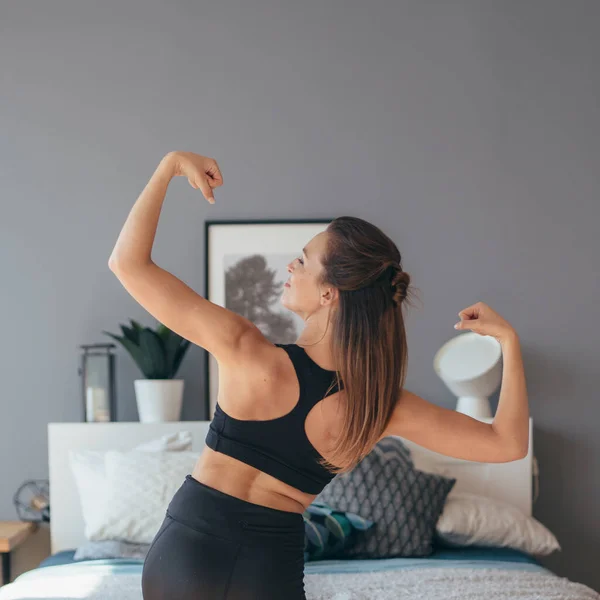 Fit femme en vêtements de sport montrant ses muscles. Vue arrière . — Photo