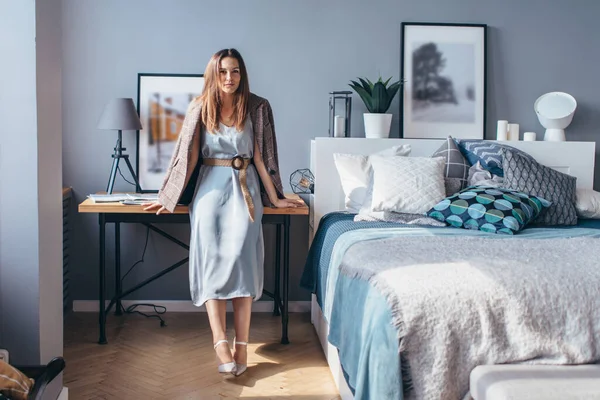 Mujer en casa está en el dormitorio en la mesita de noche . — Foto de Stock