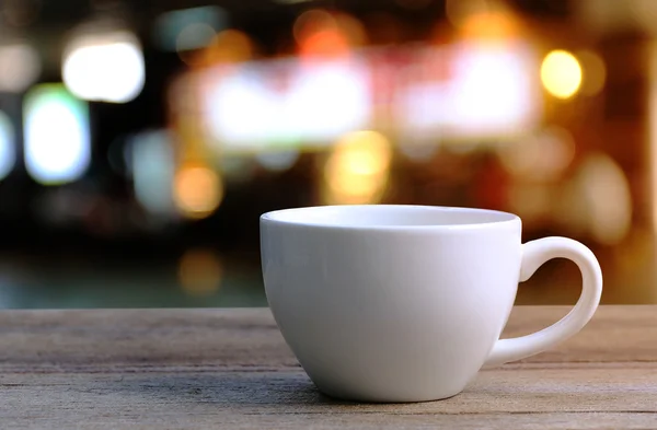 Taza de café blanco en la mesa de madera en la cafetería fondo borroso . —  Fotos de Stock