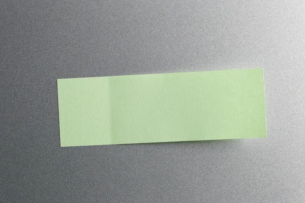 冷蔵庫の背景に置かれた緑のメモ紙. — ストック写真