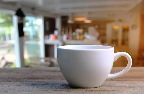 Taza de café blanco en la mesa de madera en la cafetería fondo borroso . —  Fotos de Stock