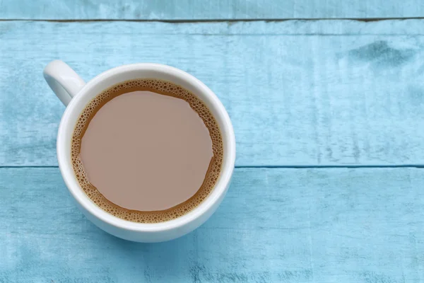 Café quente em uma xícara de café branco na mesa de madeira azul . — Fotografia de Stock