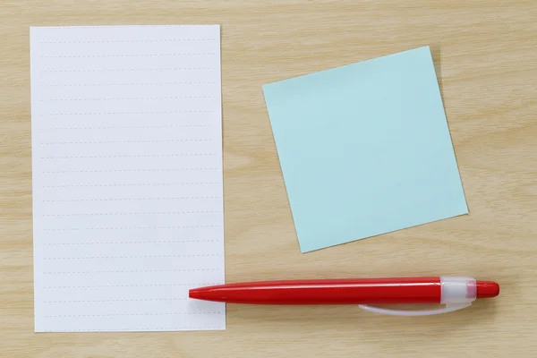 Notizpapier und roter Stift auf Holzboden gelegt. — Stockfoto