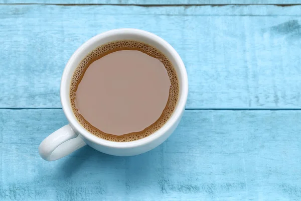 Horká káva v bílý šálek kávy na modré dřevěný stůl. — Stock fotografie