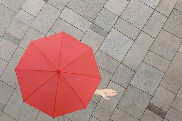 Parapluie rouge et une main d'homme debout sur le sol en pierre et la main — Photo