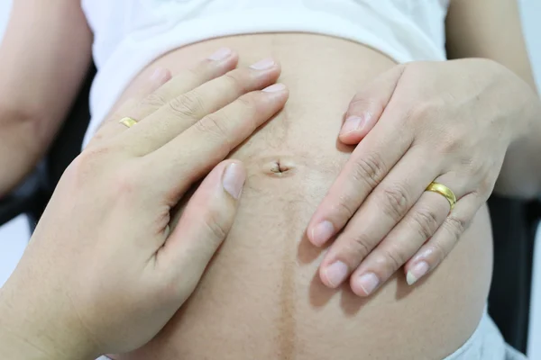 Schwangere Hand und Ehemann Hand auf Bauch gelegt. — Stockfoto