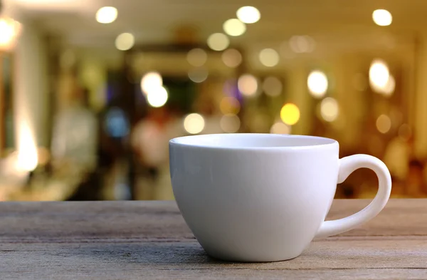 Taza de café blanco en la mesa de madera en la cafetería fondo borroso . —  Fotos de Stock