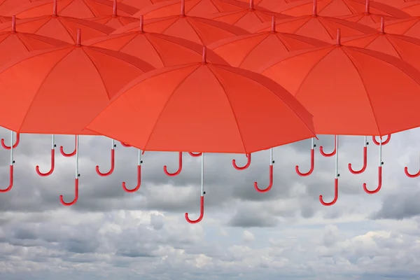 要下雨了很多红色的伞，在顶部和天空. — 图库照片