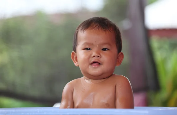 Asian baby bathing in a blue swimming pool with happily. — Stock Photo, Image