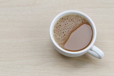 ahşap masa üzerinde beyaz bir kahve fincan sıcak kahve.