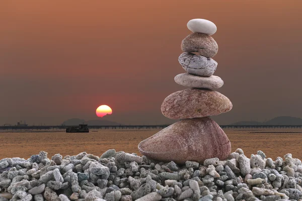 Pierre d'équilibre sur pieu rocher de fond de coucher de soleil dans la soirée . — Photo