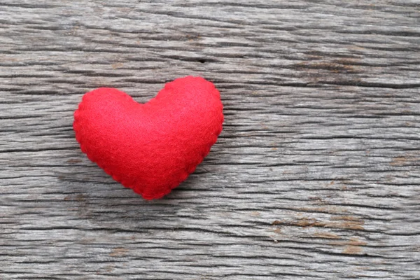 Coração vermelho é colocado em um piso de madeira . — Fotografia de Stock