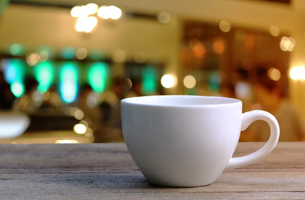 Taza de café blanco en la mesa de madera en la cafetería fondo borroso . —  Fotos de Stock