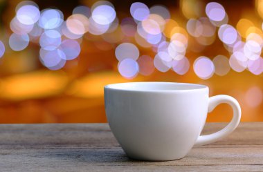 Beyaz kahve fincanı kahve dükkanında ahşap masa üzerinde arka plan bulanıklık.