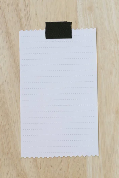 Fehér papír üres vagy Megjegyzés papír a barna fa padló. — Stock Fotó