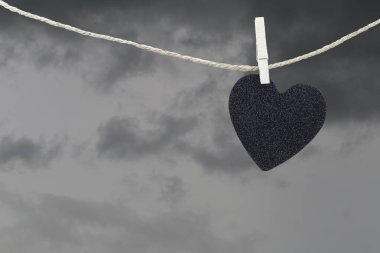 Yağmur bulutları ba kahverengi kenevir ipte asılı Black Heart kağıt