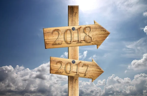 Wood sign of 2017 and 2018 in in right on blue sky background. — Stock Photo, Image