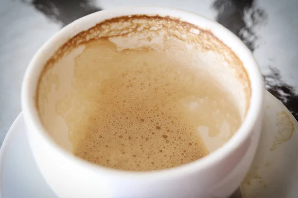 Witte koffiemok met koffie vlekken op tafel. — Stockfoto