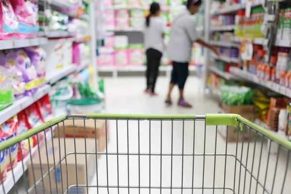 Mand van winkelen trolley en onscherpte supermarkt achtergrond. — Stockfoto