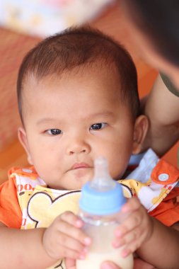 Asya bebek ve şişe süt mevcut.