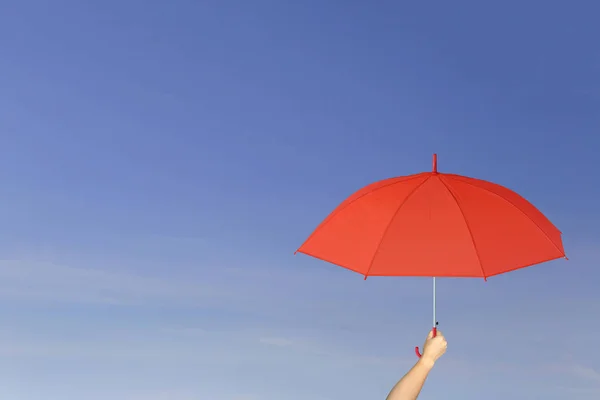 蓝蓝的天空背景上的手中红伞. — 图库照片